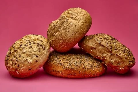 Three assorted bread rolls on pink studio surface Stock Photos