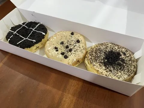 Three assorted donuts in a box. Stock Photos