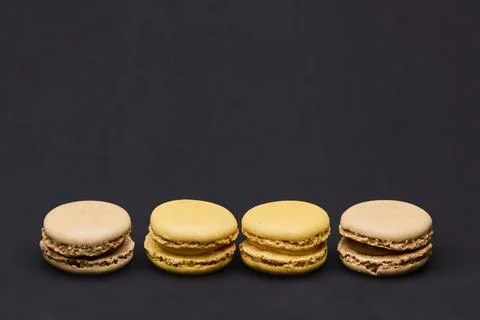 Three assorted macarons on dark background gourmet dessert concept Stock-Fotos