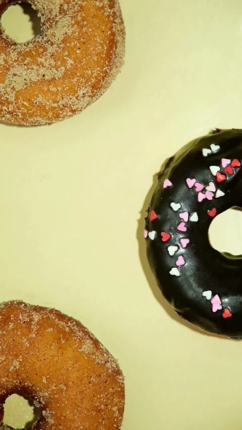 Three assorted sweet donuts on a bright yellow background Video stock 331781046