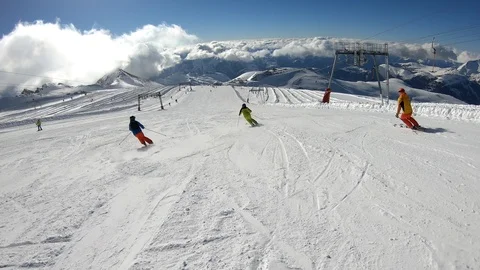 Three Athletes Ski Downhill in a Synchronized Manner in the French Alps Stock Footage 105429055