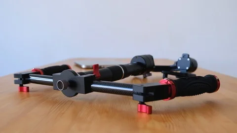 Three-axis rig for video shooting lies on table against the background of laptop Stock Footage 99641233