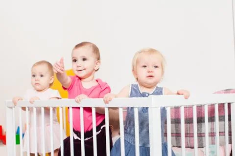 Three baby girls in the crib Stock Photos