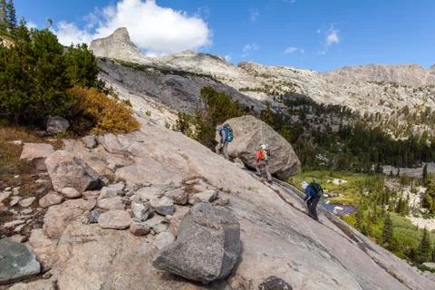 Three backpackers ascend rockface - Wind River Range, Wyoming Stock Photos