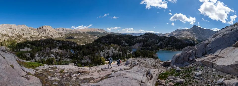Three backpackers ascend rockface - Wind River Range, Wyoming Stock Photos