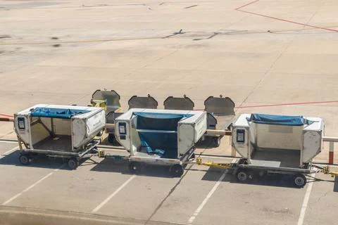 Three Baggage Carts Aligned on Airport Apron Stock Photos
