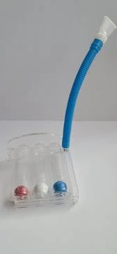 Three-ball respiratory spirometer on white background for lung exercises. Stock Photos
