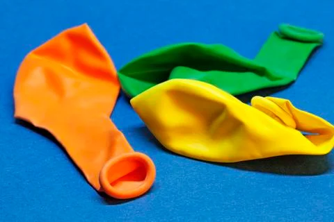 Three balloons that are not inflated on blue background Stock Photos