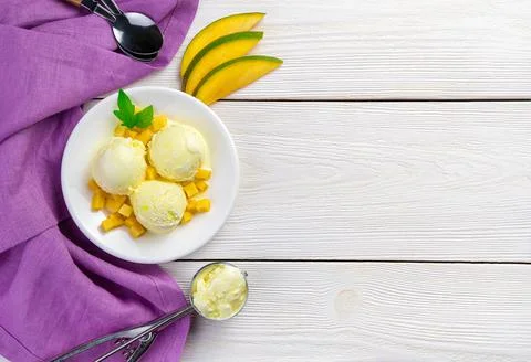 Three balls of mango ice cream fresh mango slices on a white background with  Stock Photos