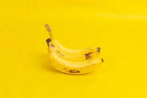 Three bananas on yellow background Stock Photos