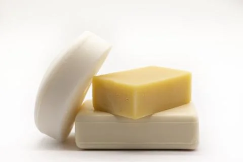 Three bars of soap rest on a clean white surface Stock Photos