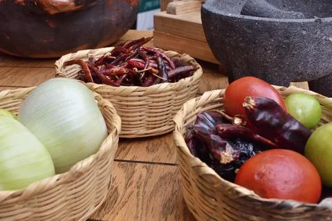 Three baskets of food on a table, one with onions, one with tomatoes Foto stock