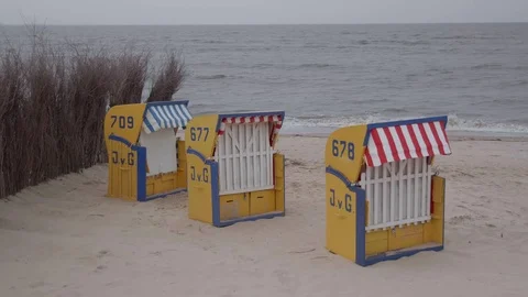 Three beach chairs in front of north sea on an overcast day Stock Footage 99910403