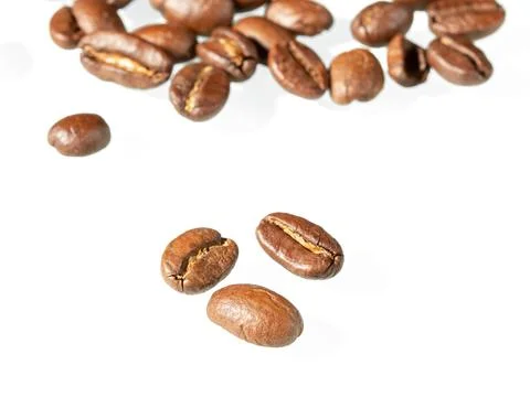 Three beans of roasted coffee close-up and a bunch of coffee beans in the b.. Stock Photos