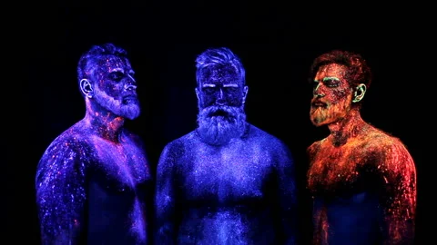 Three bearded men in UV powder are standing static Stock Footage 110870626