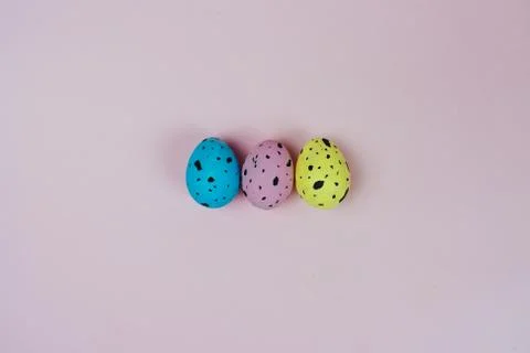 Three beautiful painted Easter eggs isolated on pink background. Quail eggs Stock Photos