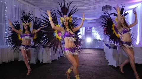 Three beautiful slim girl dancing samba in white decorated hall. Costumes in Stock Footage