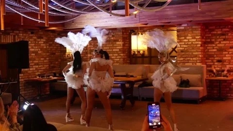Three beautiful slim girls dance erotic dances with feathers in cabaret style Stock Footage 301702996
