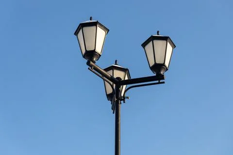 Three beautiful street white rectangular lighting lanterns with snow on black Stock Photos