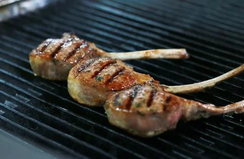 Three beef bone in rib eye steak with grill marks on grill. Stock Photos