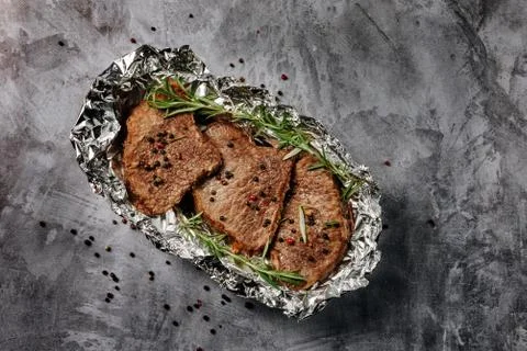 Three beef steaks cooked in foil. Stock Photos