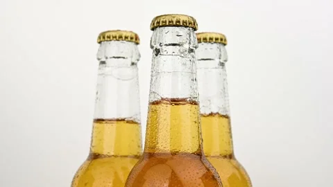 Three beer bottles rotating over white Stock Footage 134823981