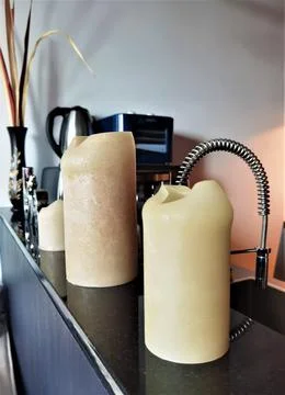 Three beige candles on the kitchen table 写真素材