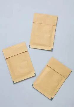 Three beige paper envelopes on light blue background Stock Photos