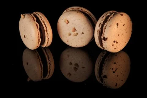 Three beige peanut macarons with chocolate filling Foto stock