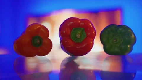 Three bell peppers in orange red and green on reflective surface Stock-Footage 331983672