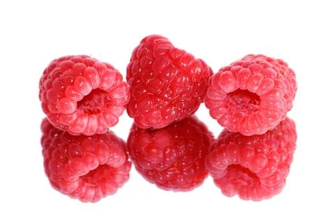 	Three berries of a raspberry are reflected in a mirror Stock Photos