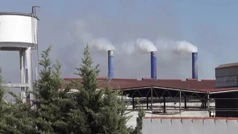Three big chimneys rejecting white smoke into blue sky. Industrial pollution Stock Footage 151112542