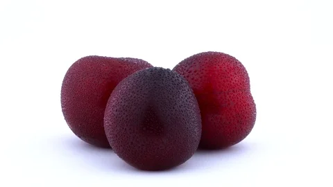 Three big purple maynard plums with water drops rotating on the turntable. Stock Footage 93632869