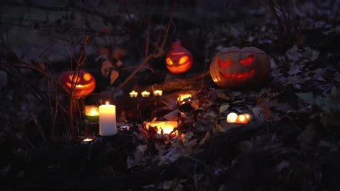 Three big scary orange terrifying pumpkin Jack lantern heads, white burn candles Stock Footage 139200501