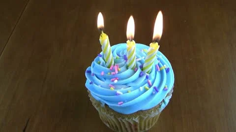 Three birthday candles on a cupcake Stock Footage