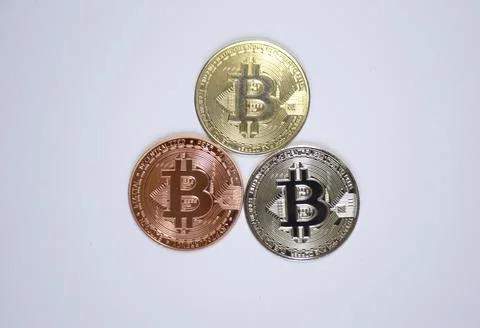 Three bitcoin coins in the shape of a triangle on a white background Stock Photos