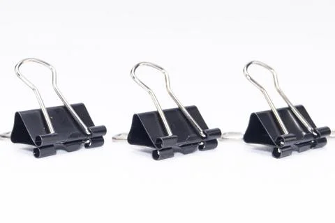 Three Black Binder Clips in a Row on White Background, Office Supplies, Sta.. Stock Photos