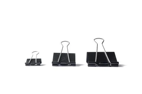 Three black binder clips of various sizes used to staple documents against Stock Photos