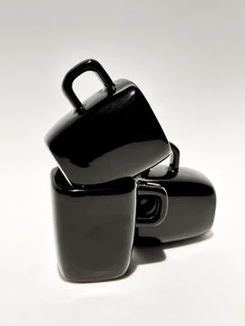 Three black ceramic cups stacked forming a tower of cups Foto stock