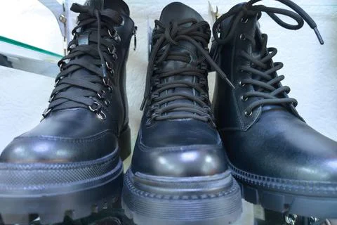 Three black leather combat boots with laces Stock Photos