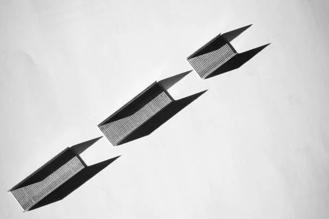 Three black parallelogram shapes made of staples arranged on white Foto stock