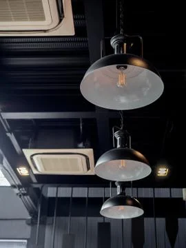 Three black round modern ceiling lights and cassette type air conditioner ins Stock Photos