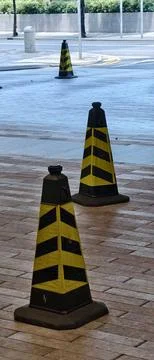 Three black traffic cones with bold yellow diagonal stripes 库存照片