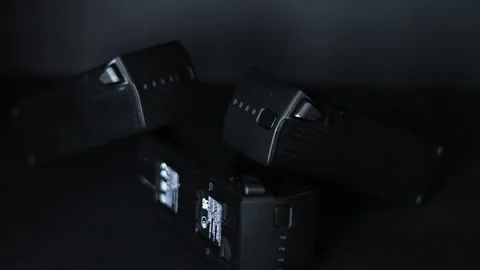 Three black uas drone batteries stacked on top each other against a black Stock Footage 270362347