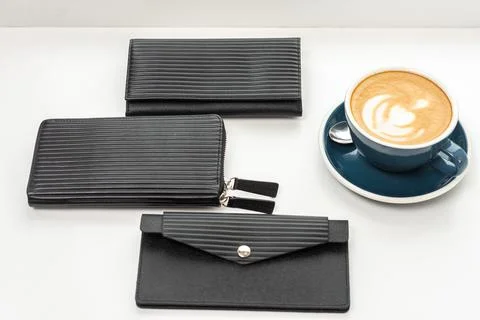 Three black wallets on a white table with a cup of coffee Stock Photos