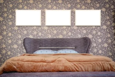 Three blank frames above modern bedroom bed Foto stock