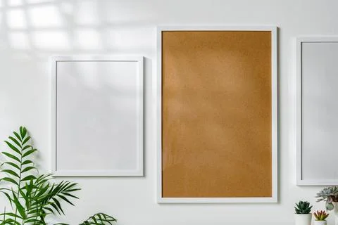 Three blank frames with copy space hanging on white wall Stock Photos