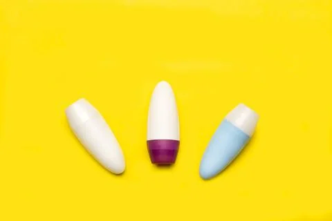 Three blank plastic bottles on a yellow background with copy space Stock Photos