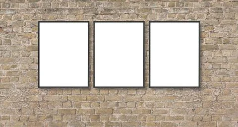 Three blank poster frames hanging on brick wall for display Stock Photos