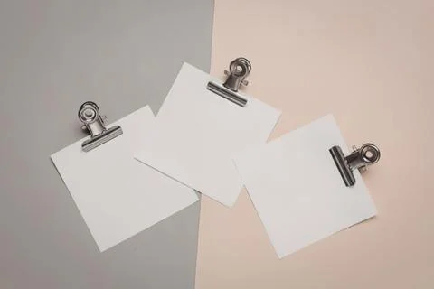 Three blank white paper sheets clipped on colorful backgrounds Stock Photos